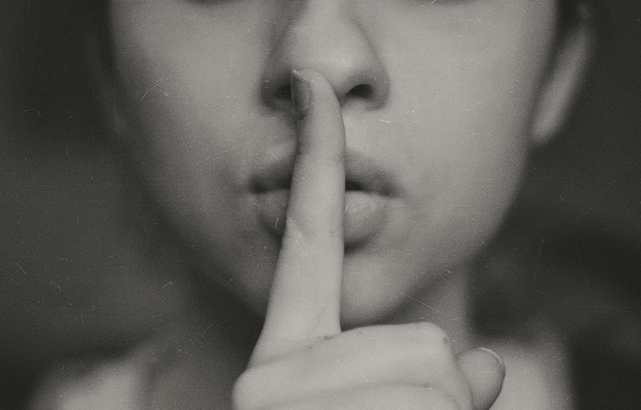 Picture of a woman with her finger to her lips
