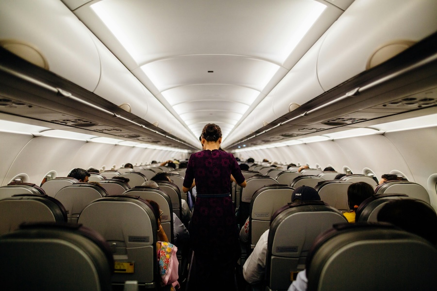 Picture of a woman standing in the aisle of a plane