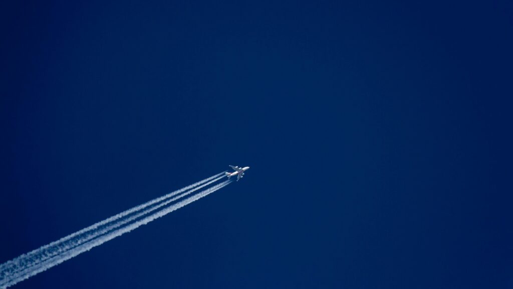 Picture of a plane with vapour trails in the sky