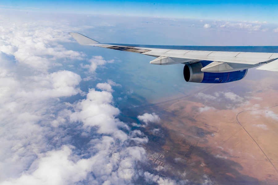 Picture of a plane flying high above the ground on a light day