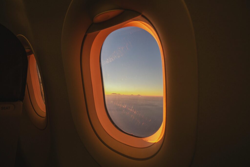 Picture of an airplane window during sunrise