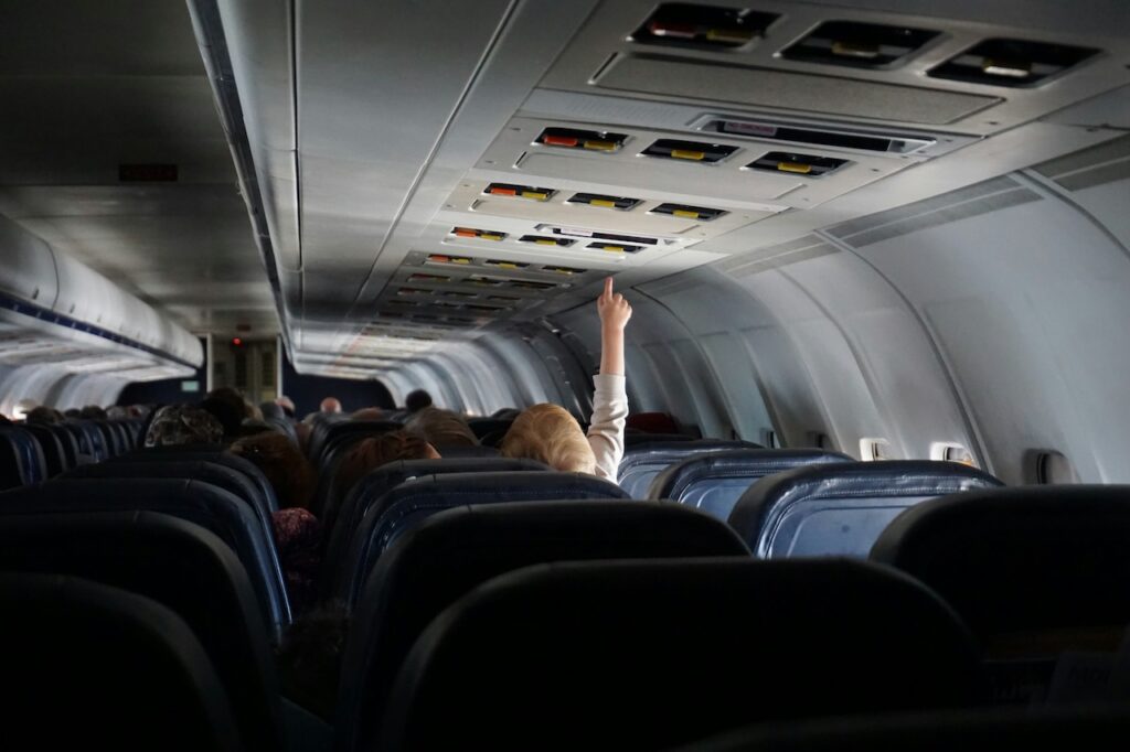 Child with their hand up inside a plane