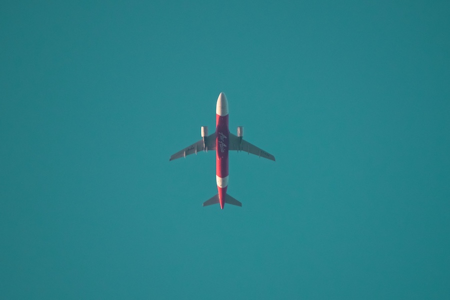 Picture of a plane from below on a beautiful blue sky