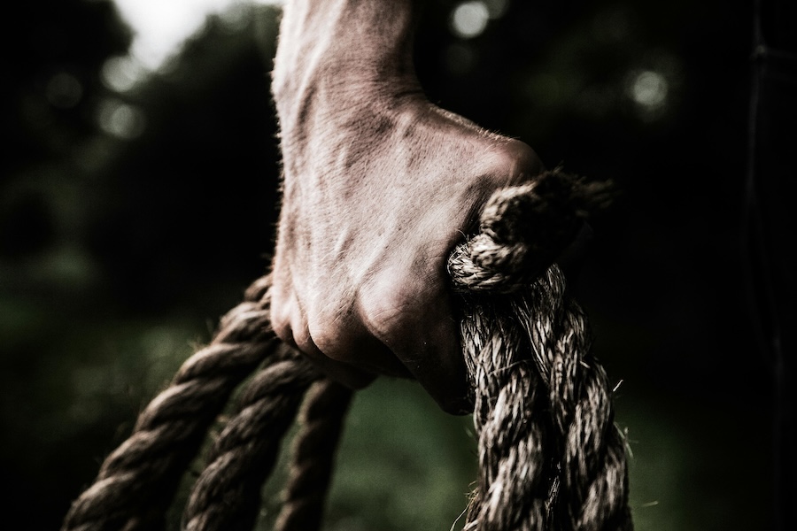 Man grasping some rope in a show of strength