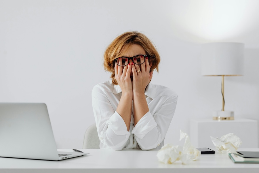 Middle aged woman with her head in her hands