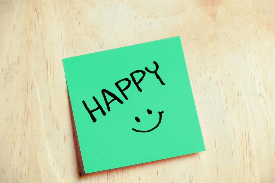 Image of a post it note saying "Happy" on a green background