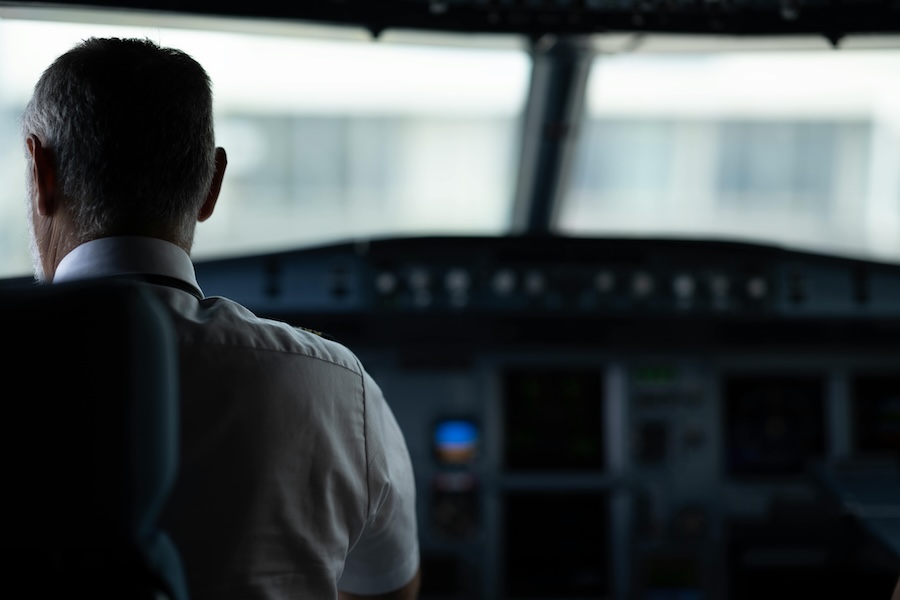Image of a pilot on the flight deck of a plane looking out of the front window