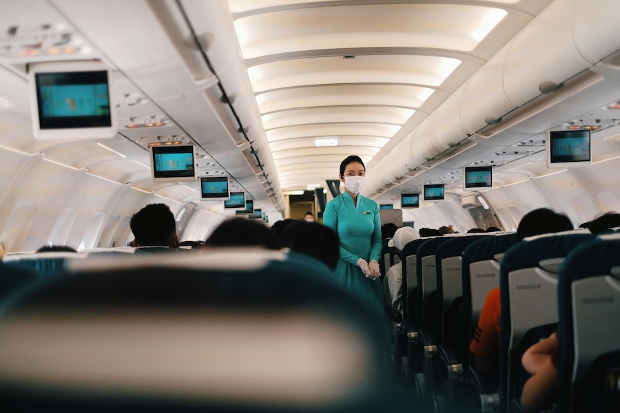 Flight attendant wearing a mask to reduce the risk of infection