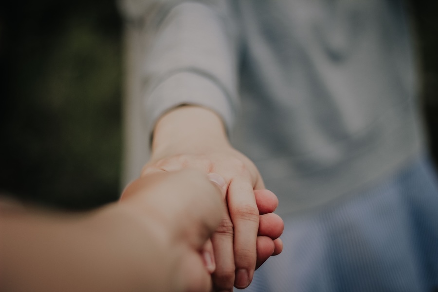 Two people holding hands and providing emotional support