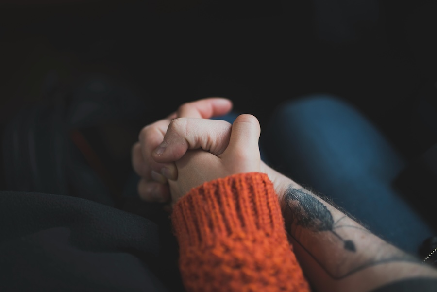 Two people holding hands on an aeroplane