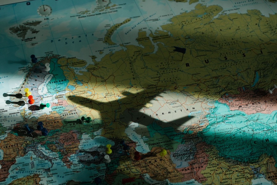 Shadow of a toy plane flying over a map of the world