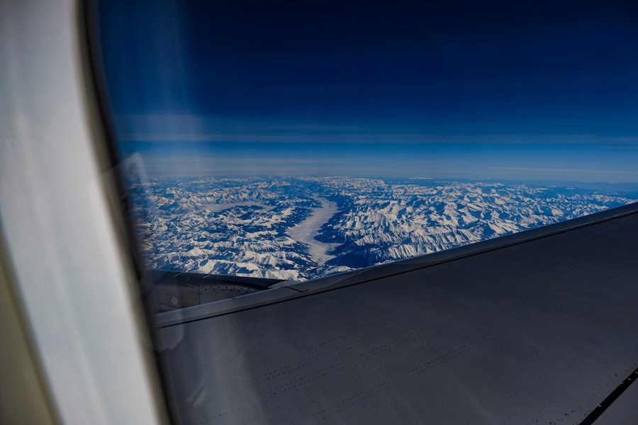 Icy mountains seen through the window of a plane