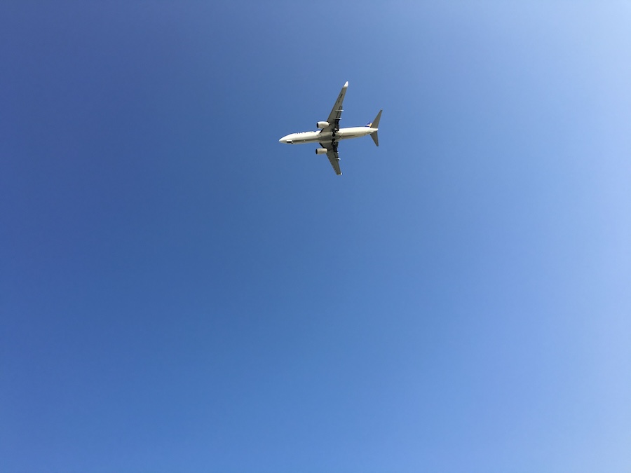 Image of a plane flying against a beautiful deep blue sky