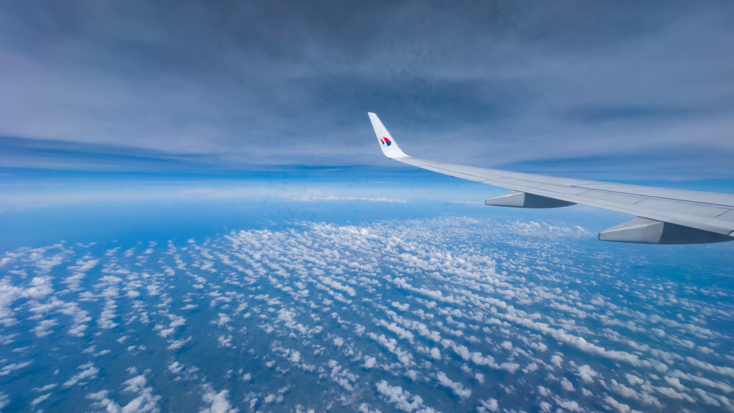 A plane wing with beautiful blue skies underneath
