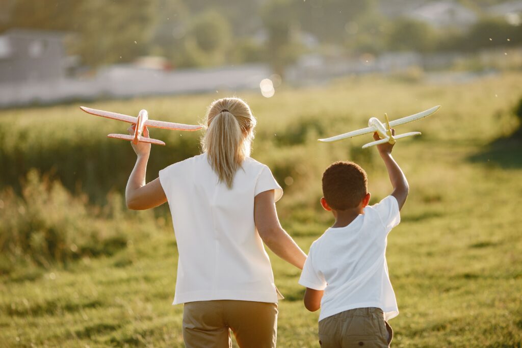 Child and their mother flying model planes on a beautifully sunny day